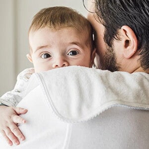 Bebé con reflujo, apoyado sobre el hombro de su papá