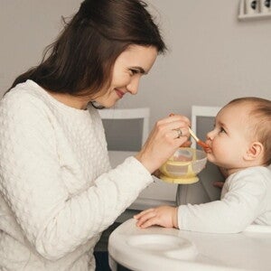 mamá dando de comer a bebé