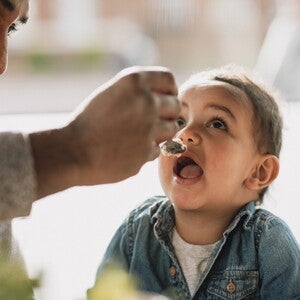 Un papá y su hijo comiendo alimentos pare evitar alergias en bebés.