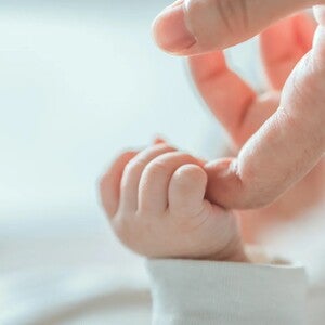 Bebé sujetando el dedo de su mamá