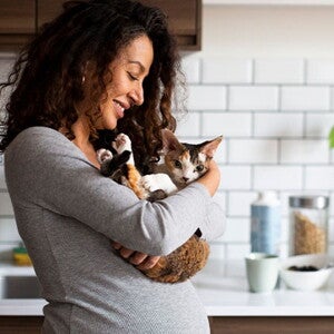 Mujer embarazada sosteniendo a su gatito