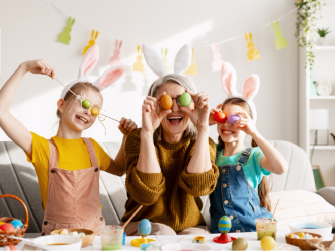 Padres y niños celebrando Pascua, cubriendo sus ojos con huevos de colores de forma divertida.