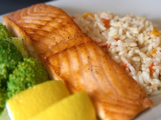 Omega-3 y el rendimiento escolar Plato con salmón a la parrilla, arroz con verduras, brócoli y rodajas de limón