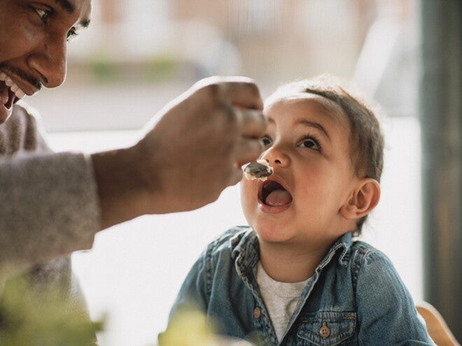 Un papá y su hijo comiendo alimentos pare evitar alergias en bebés. Un papá y su hijo comiendo alimentos pare evitar alergias en bebés.