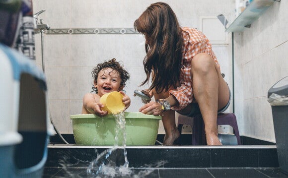 Niño pequeño divirtiéndose con su mamá a la hora del baño.