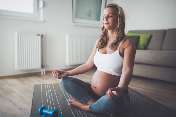 Yoga para embarazadas Mujer embarazada sentada meditando